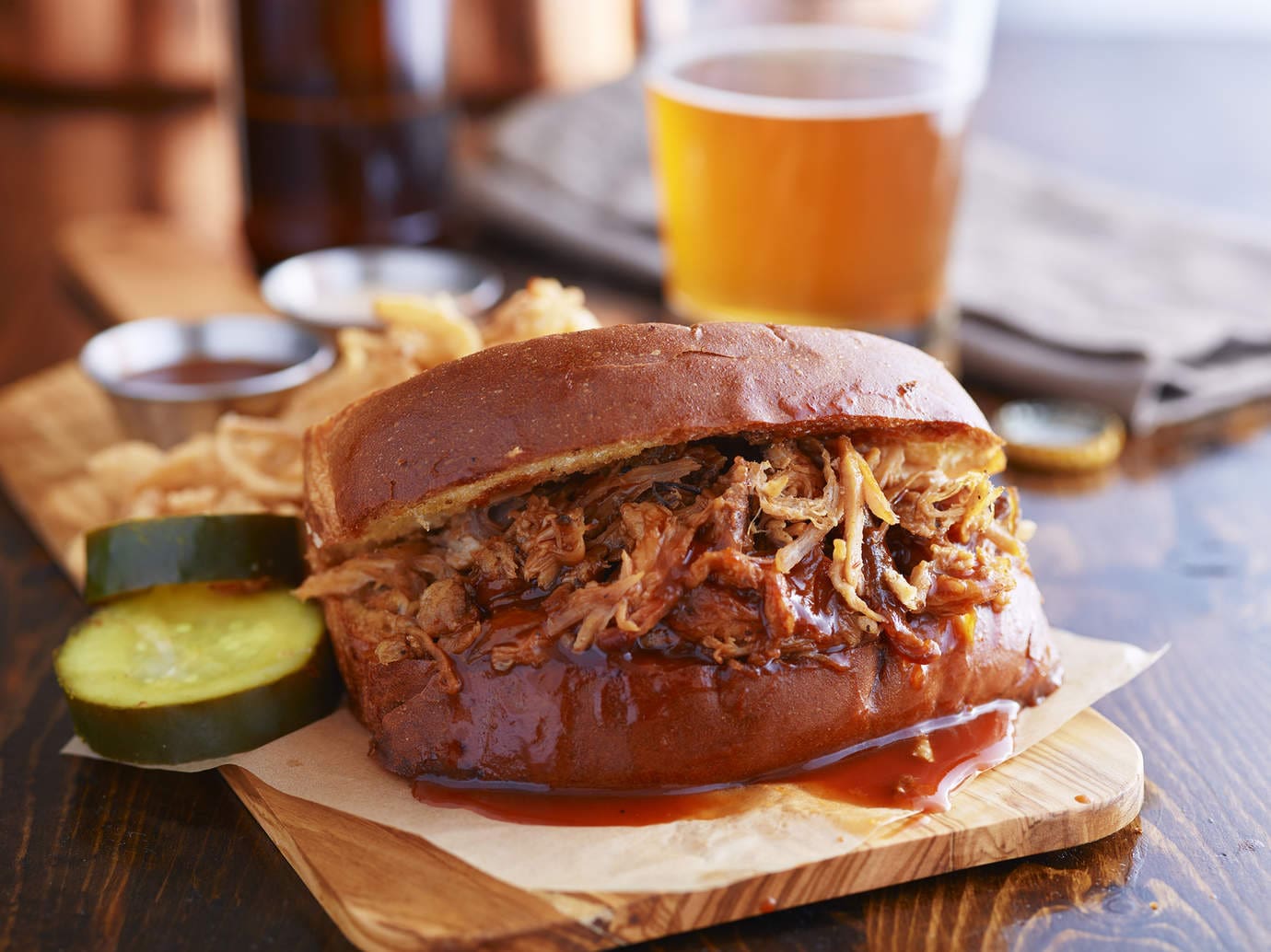 barbecue pulled pork sandwich with beer in the background